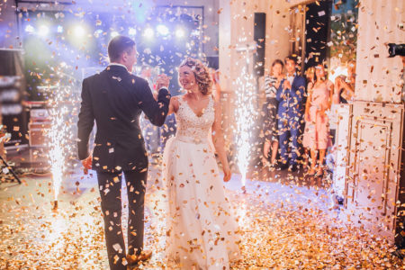 Bride and groom dancing at wedding under confetti