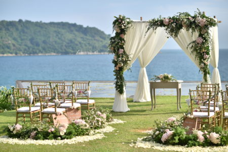 Outdoor wedding ceremony by the water and mountains