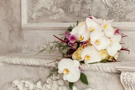 Wedding bouquet with white orchids on historial stone