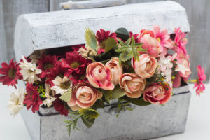 Pink and red flowers inside a vintage or antique suitcase