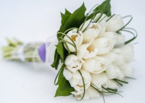 bouquet of white tulips surrounded by green leaves
