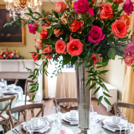 Tall centerpiece with bright pink and coral roses and greenery. Nashville wedding and event flowers by Rose Hill Flowers.